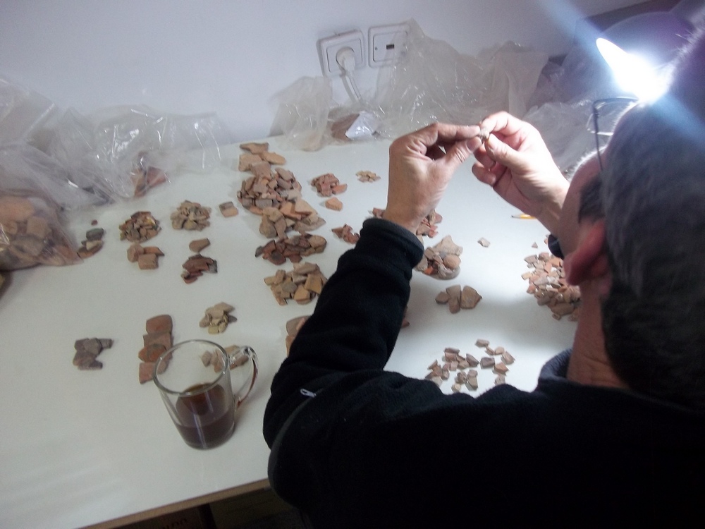 Peretz Reuven sorting pottery at the lab