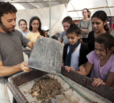 Zachi sifting with young volunteers